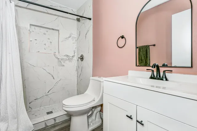 a bathroom with a sink a toilet and shower