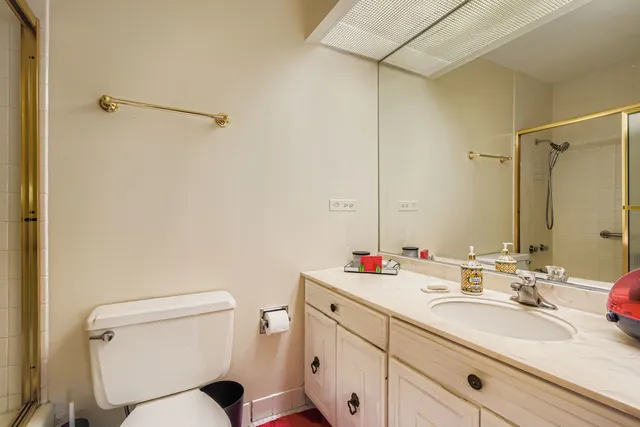 a bathroom with a toilet sink vanity and mirror