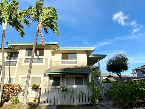 a front view of a house with a tree