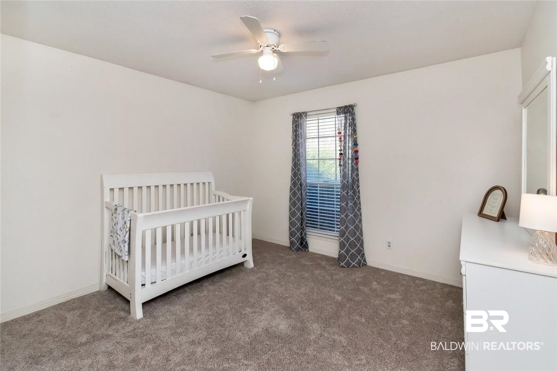 6601 Conde Court Mobile, AL 36695 - Photo 20 of 30 Unfurnished bedroom with ceiling fan, carpet, and a nursery area