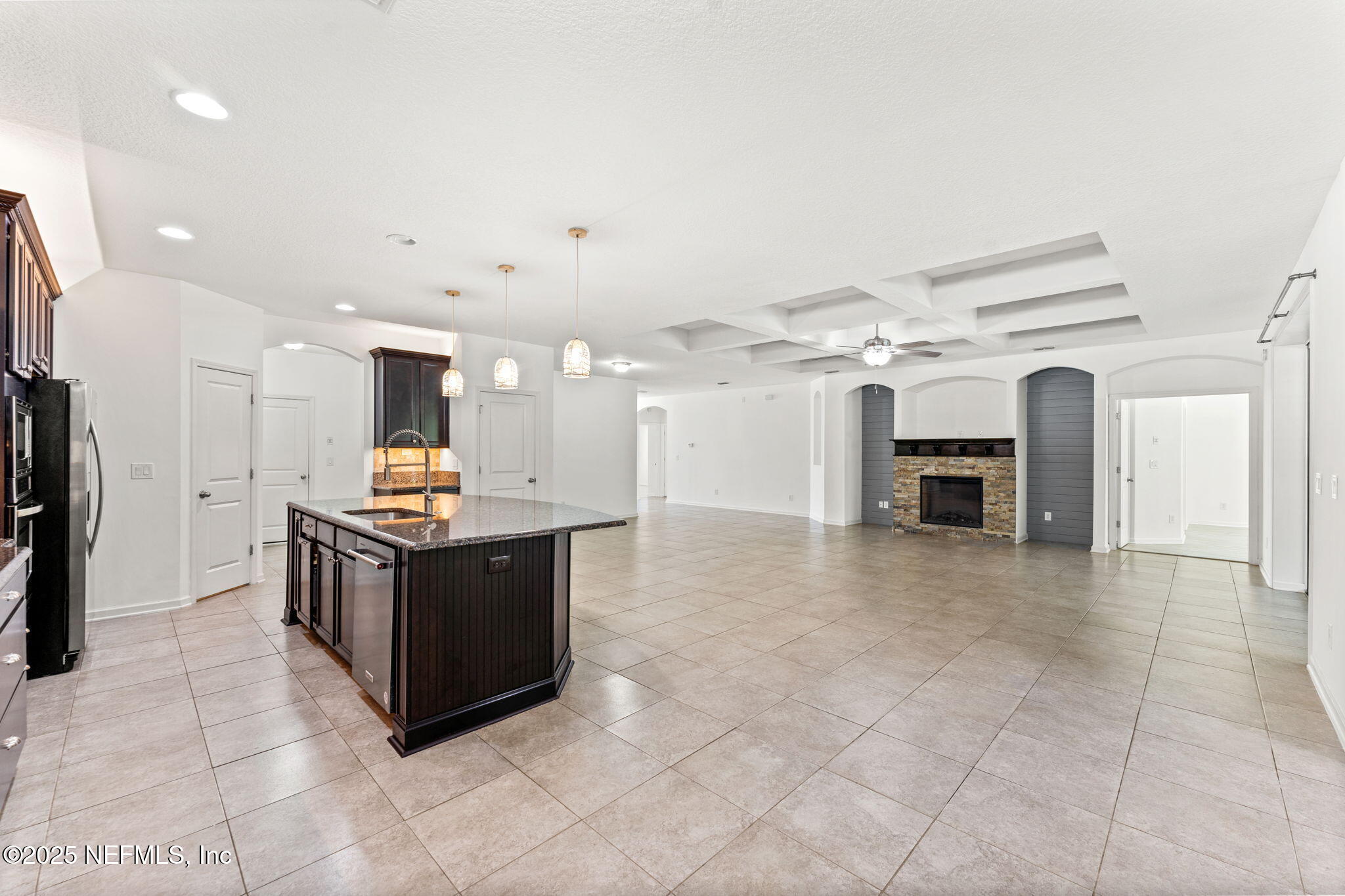 83029 Dowitcher Place Yulee, FL 32097 - Photo 12 of 40 a kitchen with kitchen island a stove a refrigerator and a sink