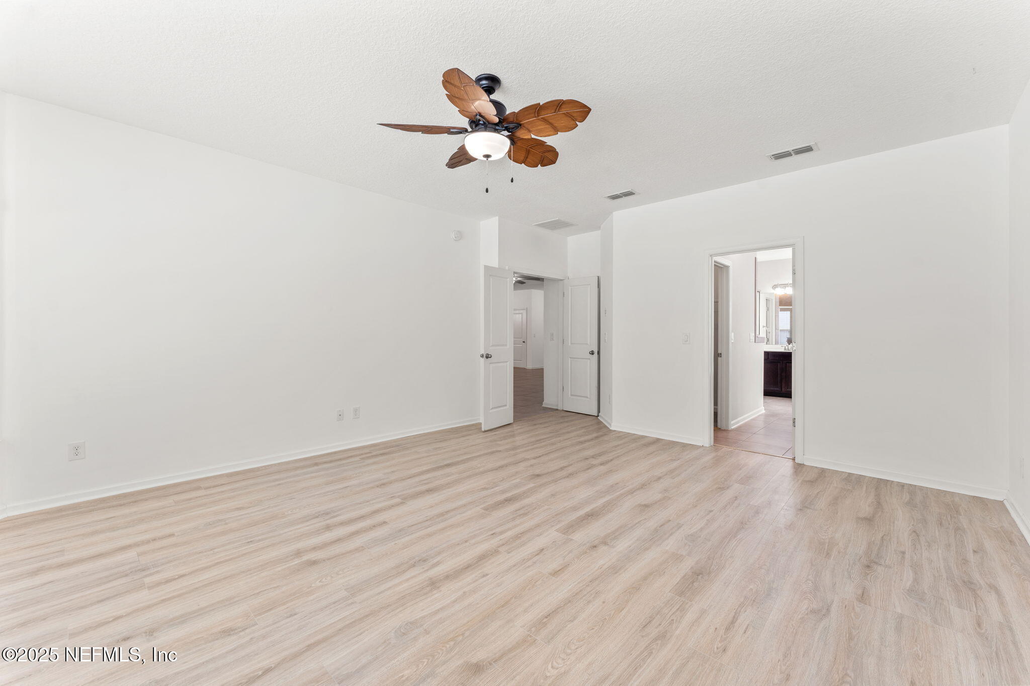 83029 Dowitcher Place Yulee, FL 32097 - Photo 18 of 40 a view of a room with wooden floor and a ceiling fan