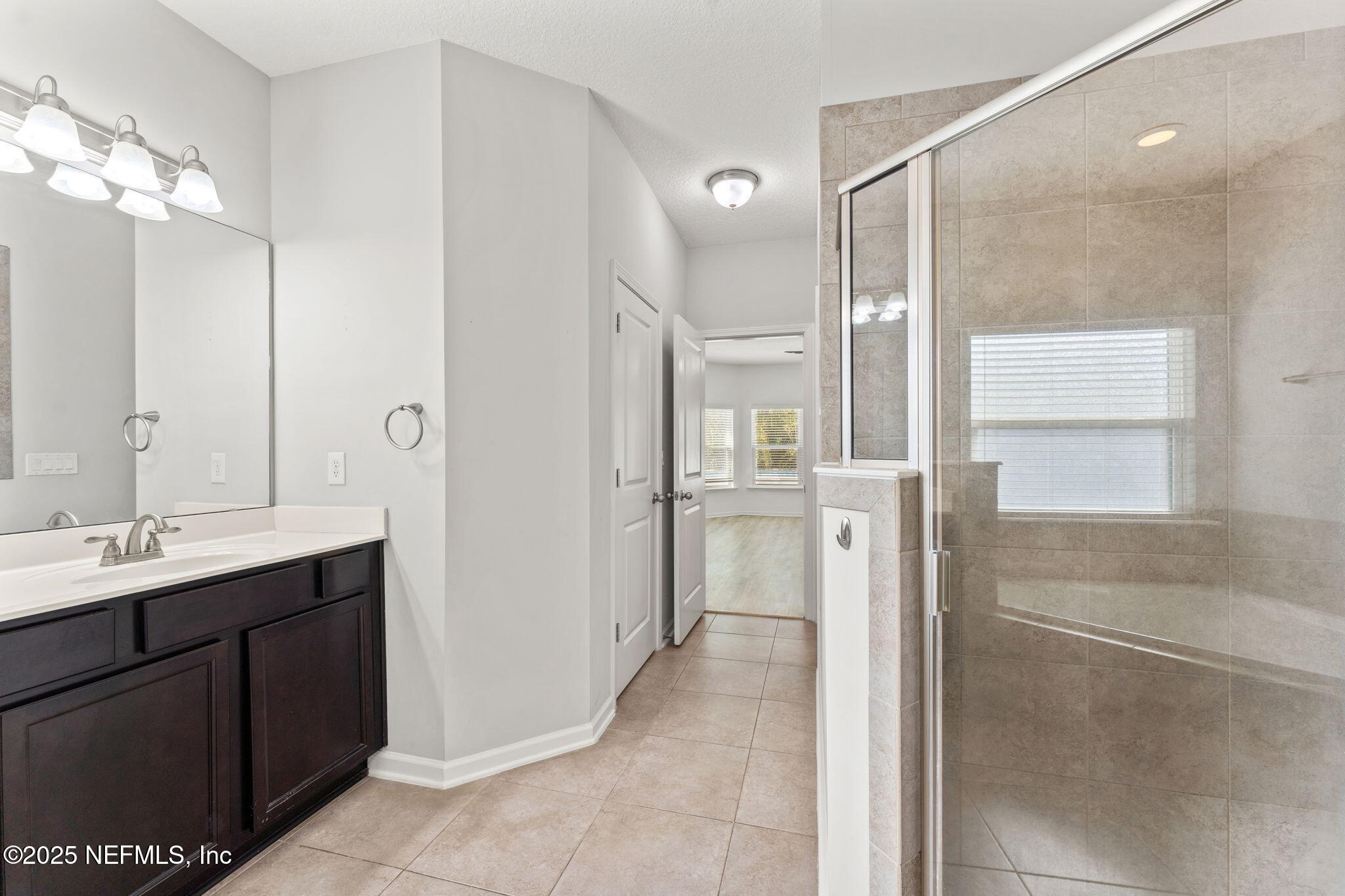 83029 Dowitcher Place Yulee, FL 32097 - Photo 19 of 40 a bathroom with a double vanity sink mirror and shower