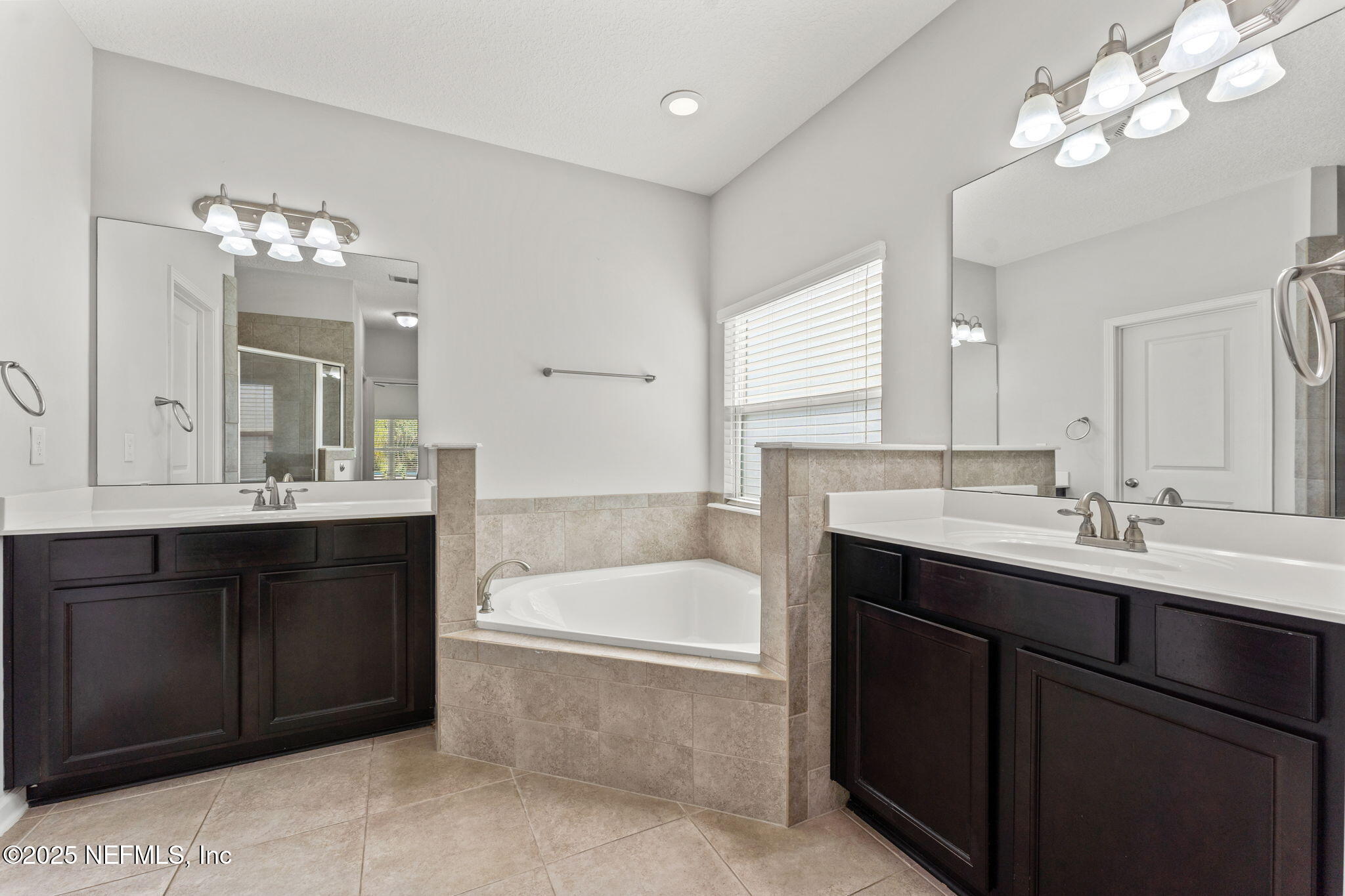 83029 Dowitcher Place Yulee, FL 32097 - Photo 20 of 40 a bathroom with a tub a double vanity sink and a mirror