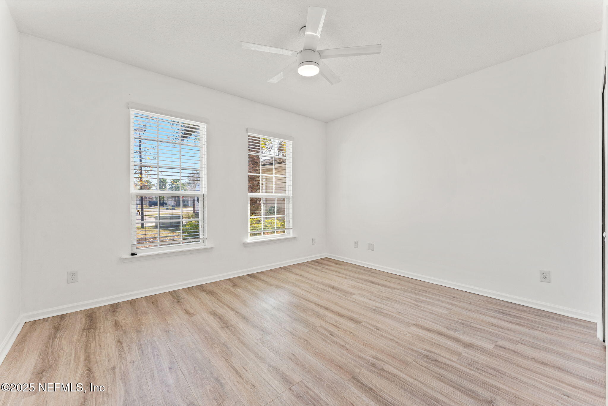 83029 Dowitcher Place Yulee, FL 32097 - Photo 22 of 40 an empty room with wooden floor ceiling fan and windows