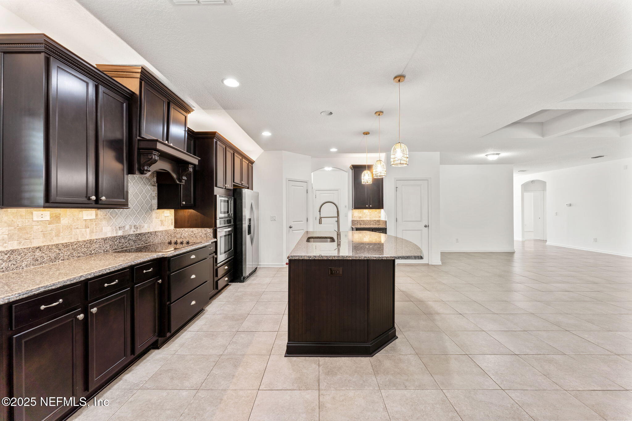 83029 Dowitcher Place Yulee, FL 32097 - Photo 10 of 40 a large kitchen with stainless steel appliances kitchen island granite countertop a large counter top and cabinets