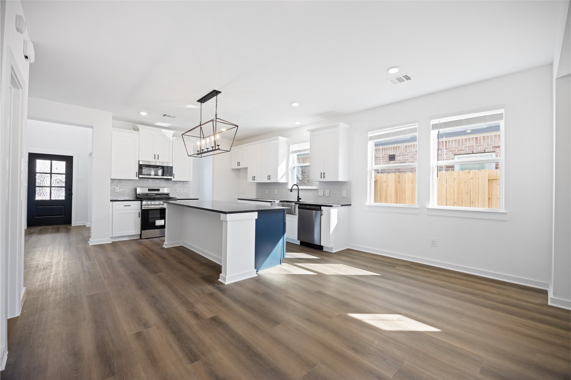 8326 Amethyst Valley Lane Angleton, TX 77515 - Photo 13 of 38 a large kitchen with cabinets wooden floor and stainless steel appliances