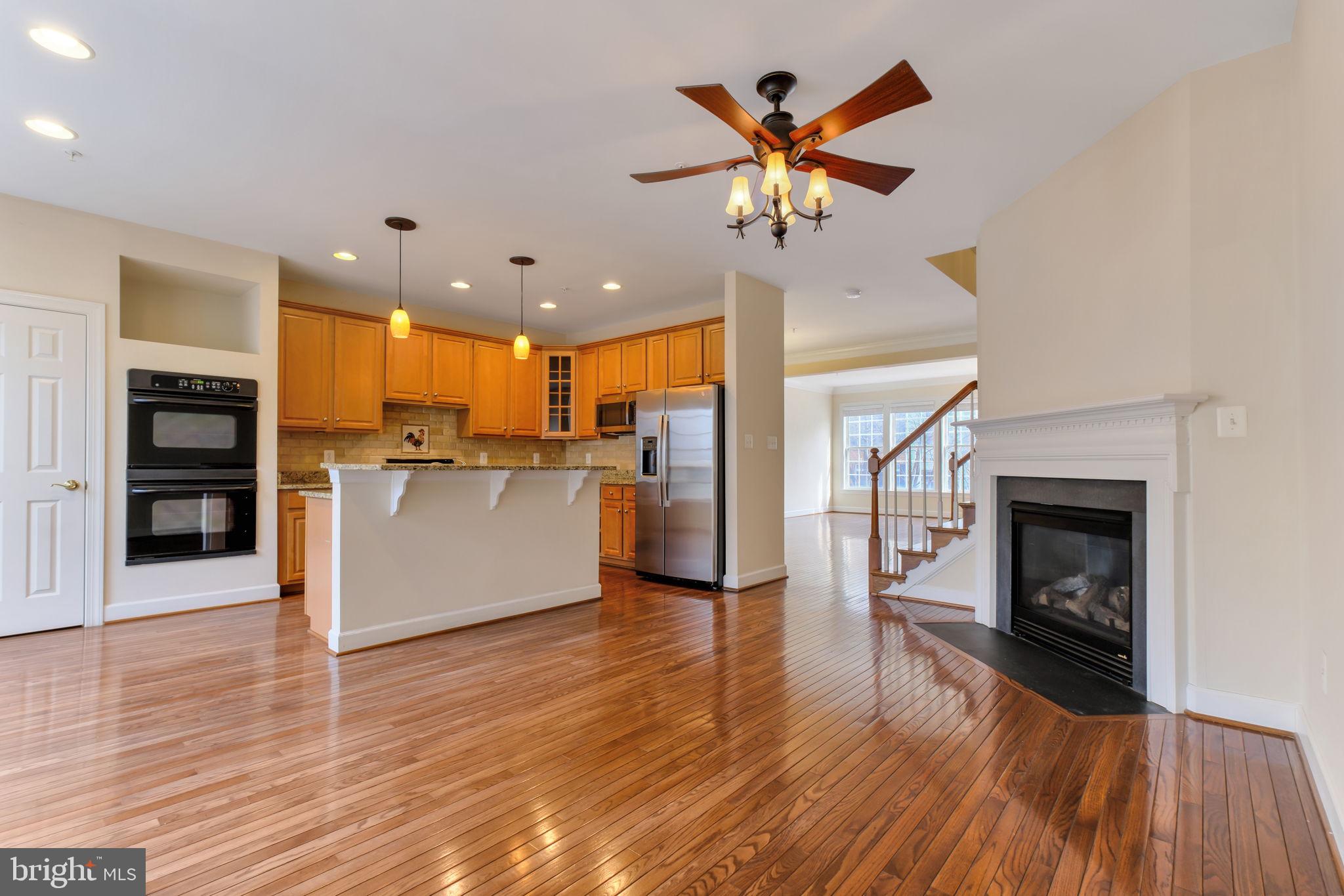 725 Ridgemont Avenue Rockville, MD 20850 - Photo 2 of 30 a view of a kitchen with a stove a refrigerator a ceiling fan and wooden floor