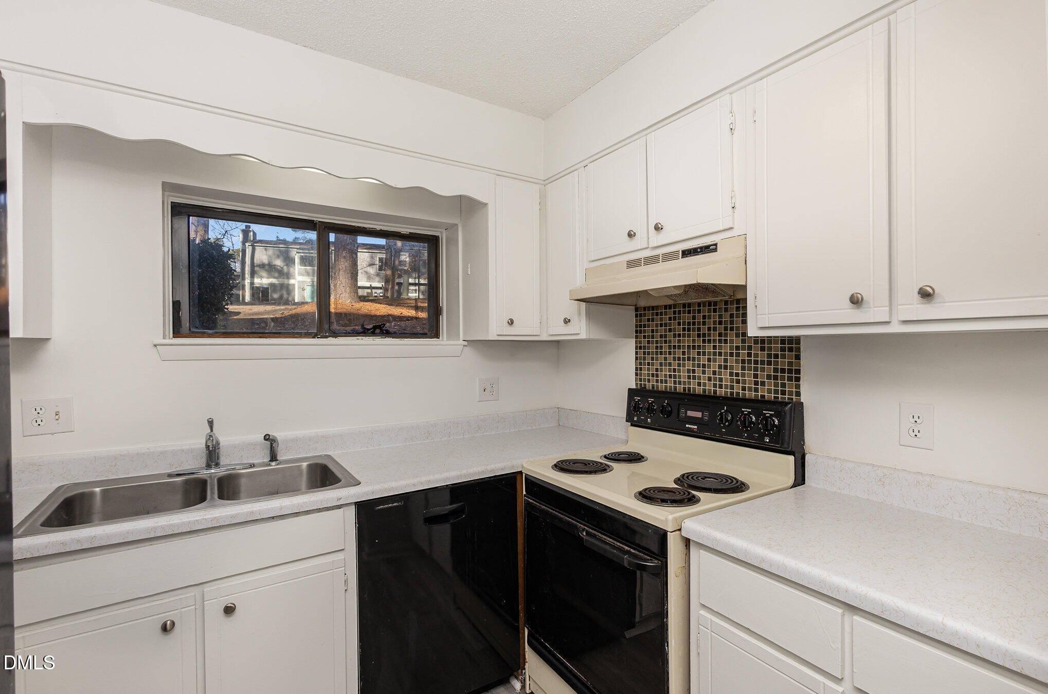 701 Godwin Court Raleigh, NC 27606 - Photo 10 of 29 a kitchen with white cabinets and white appliances