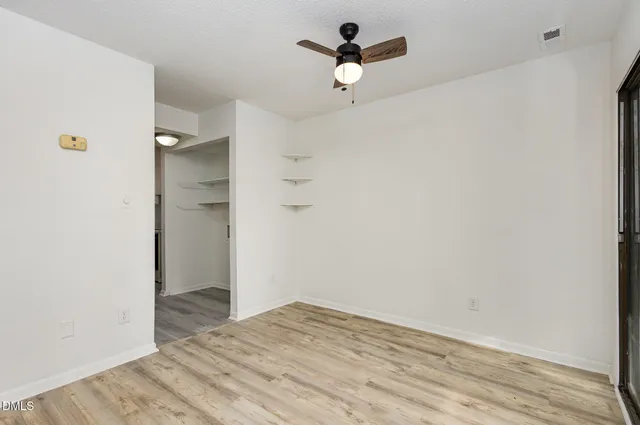 a view of empty room with wooden floor