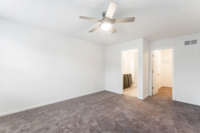 an empty room with closet and windows