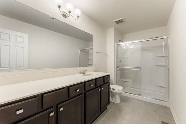 a bathroom with a double vanity sink mirror and toilet