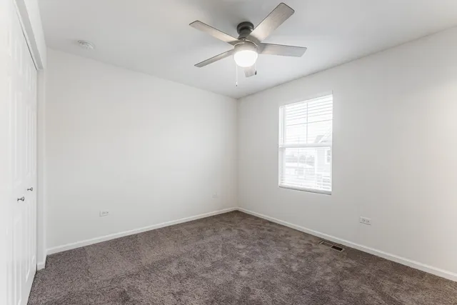 an empty room with a window and a fan