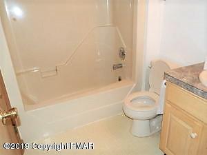 152 Chestnut Drive Bushkill, PA 18324 - Photo 16 of 34 a bathroom with a granite countertop toilet and a shower