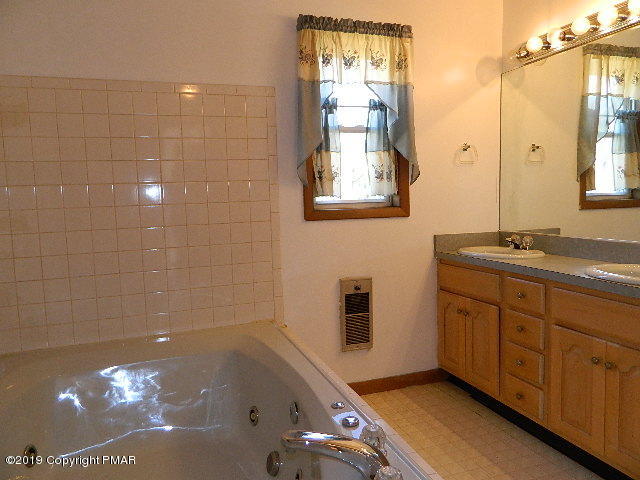 152 Chestnut Drive Bushkill, PA 18324 - Photo 24 of 34 a bathroom with a tub sink and mirror