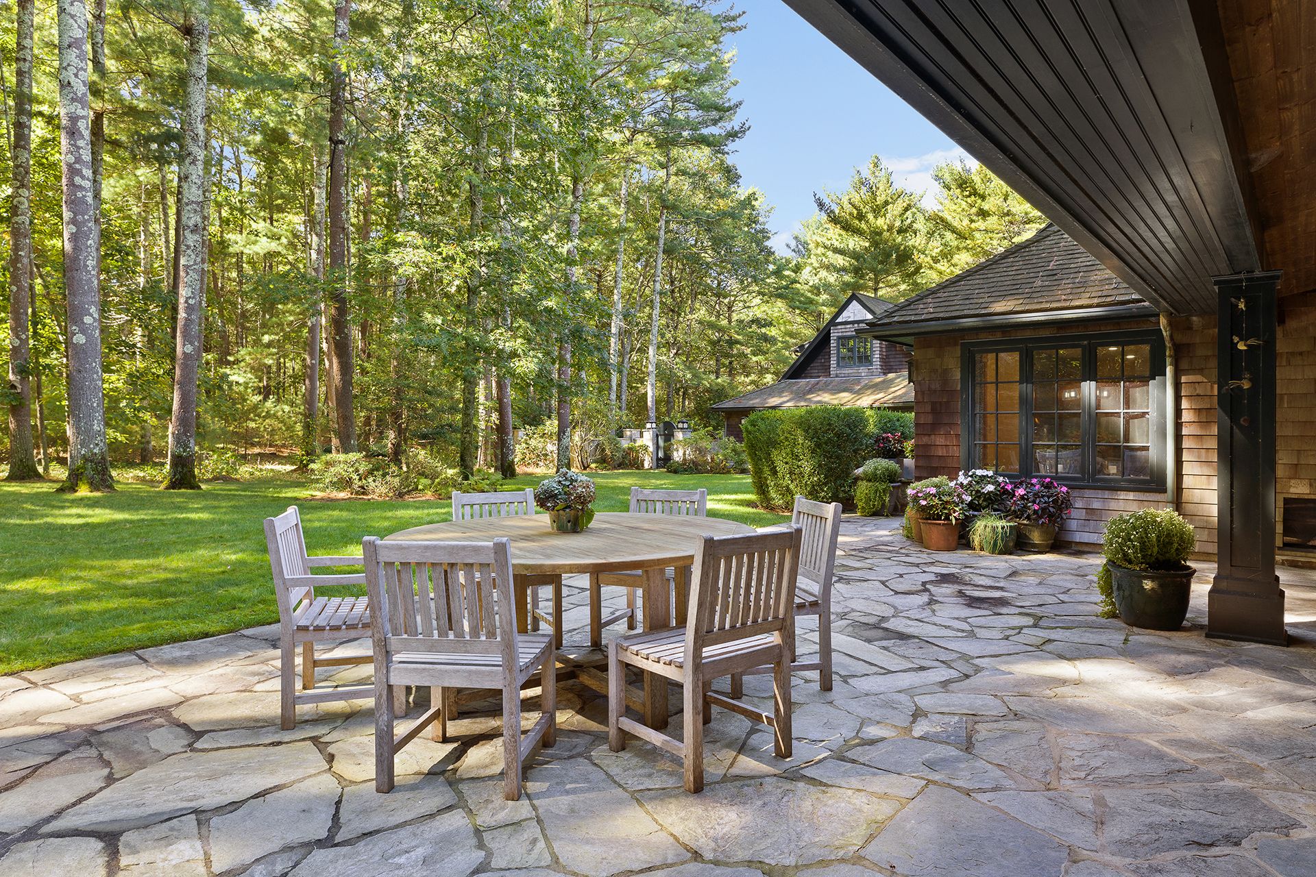 9 Two Holes Of Water Road East Hampton, NY 11937 - Photo 29 of 52 a view of a patio with table and chairs and potted plants