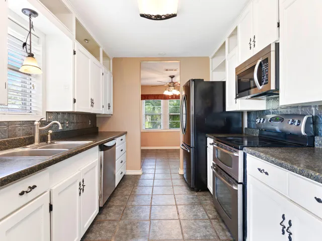 a kitchen with stainless steel appliances granite countertop a sink stove and microwave