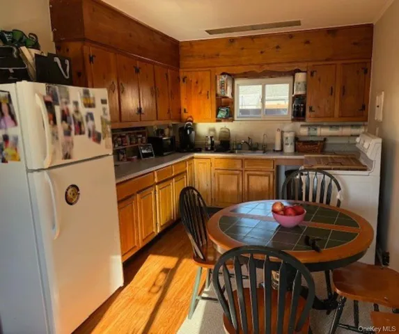 a kitchen with granite countertop a table chairs stove and refrigerator