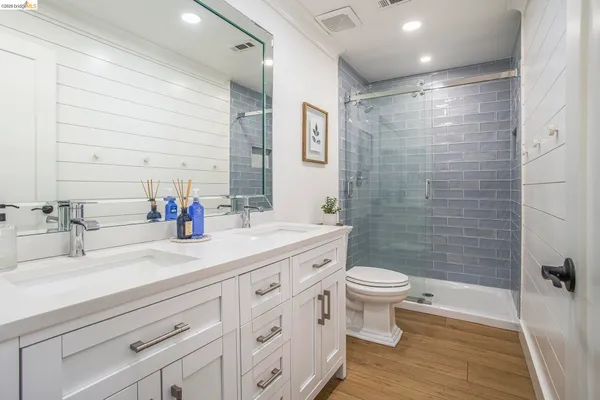 a bathroom with a sink a toilet and shower