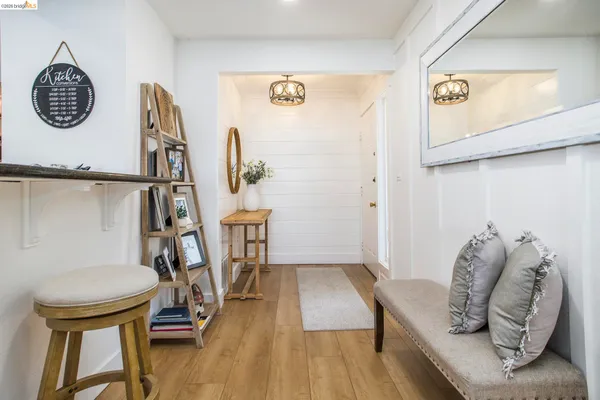 a view of a hallway with furniture and wooden floor