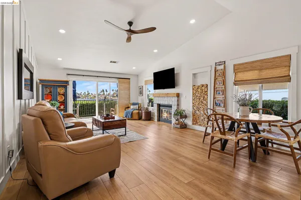 a living room with fireplace furniture and a large window
