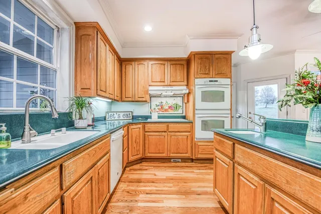 a kitchen with stainless steel appliances granite countertop a refrigerator a microwave oven a sink with cabinets and wooden floor