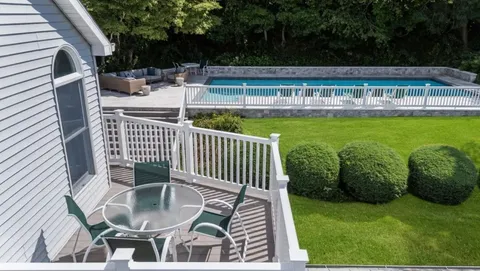 a view of balcony with two chairs and potted plants
