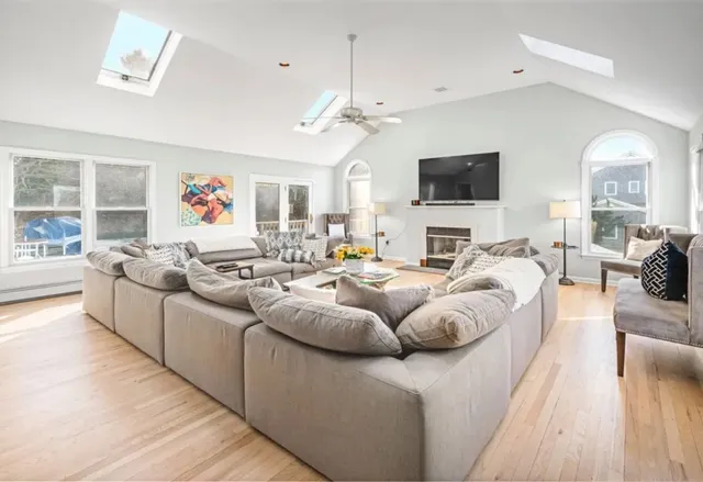 a living room with furniture kitchen view and a flat screen tv