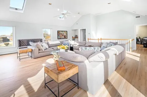 a living room with furniture and a wooden floor