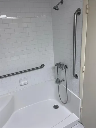 a bathroom with a bath tub with a shower