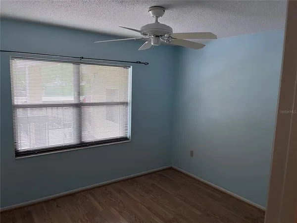 an empty room with a window and wooden floor