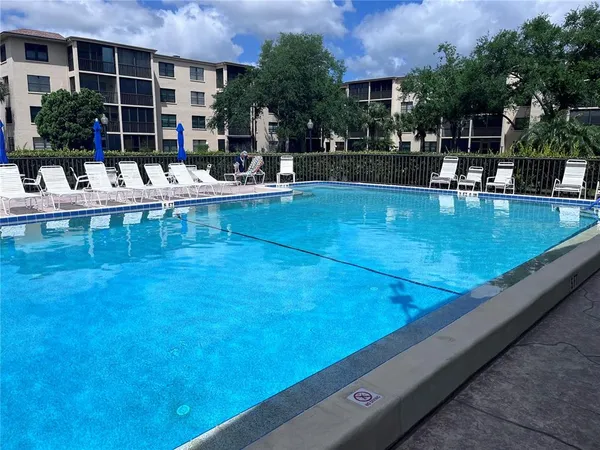 a view of swimming pool with outdoor seating and plants
