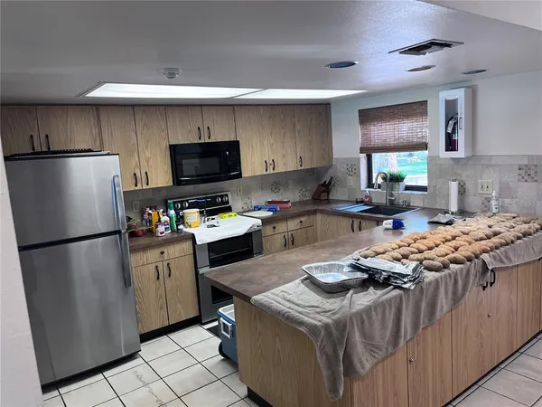 a kitchen with stainless steel appliances granite countertop a refrigerator stove a sink dishwasher and a refrigerator