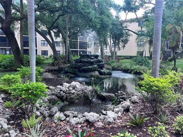a front view of a house with a yard and a pond
