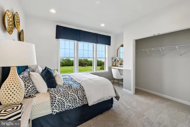 a bedroom with a bed and a large window