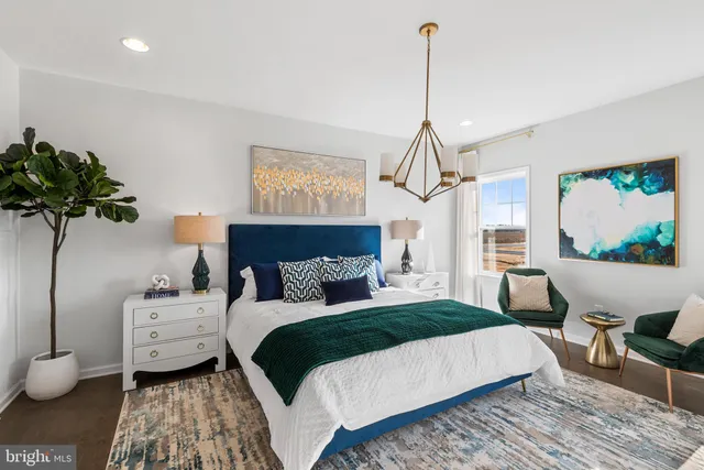 a bedroom with a bed a couch and potted plant