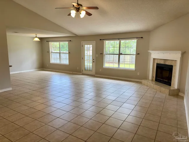 a view of an empty room with glass door and a window