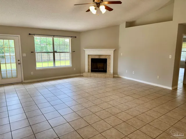 an empty room with windows and fan