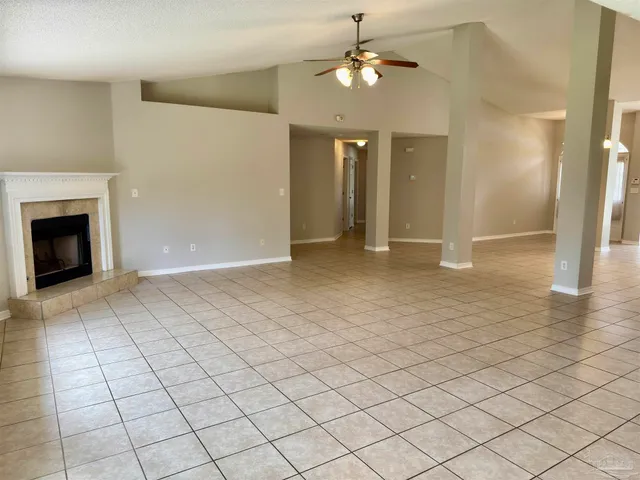an empty room with fan and view of bathroom