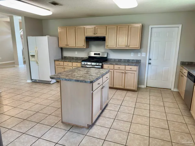 a kitchen with a stove a refrigerator and a sink