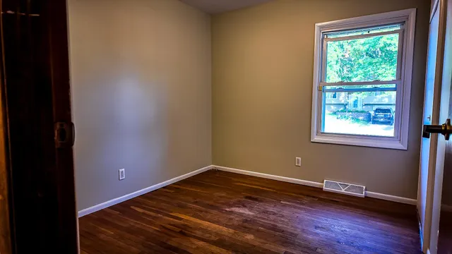 a view of a room with wooden floor and a window