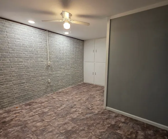 an empty room with closet and a chandelier fan