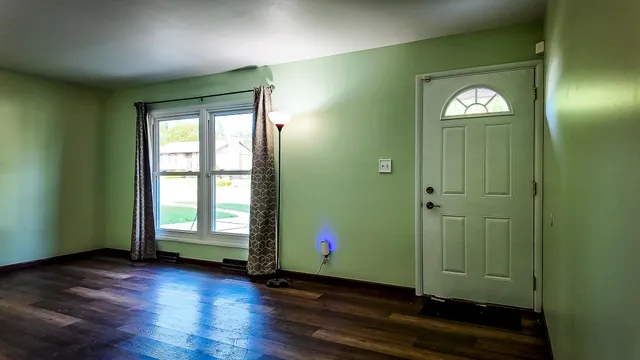 wooden floor in an empty room with a window
