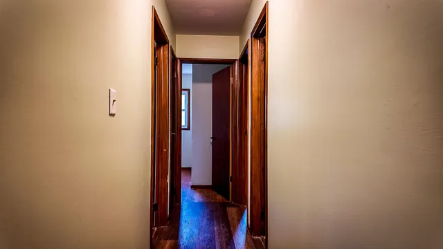 a view of a hallway with wooden floor and closet