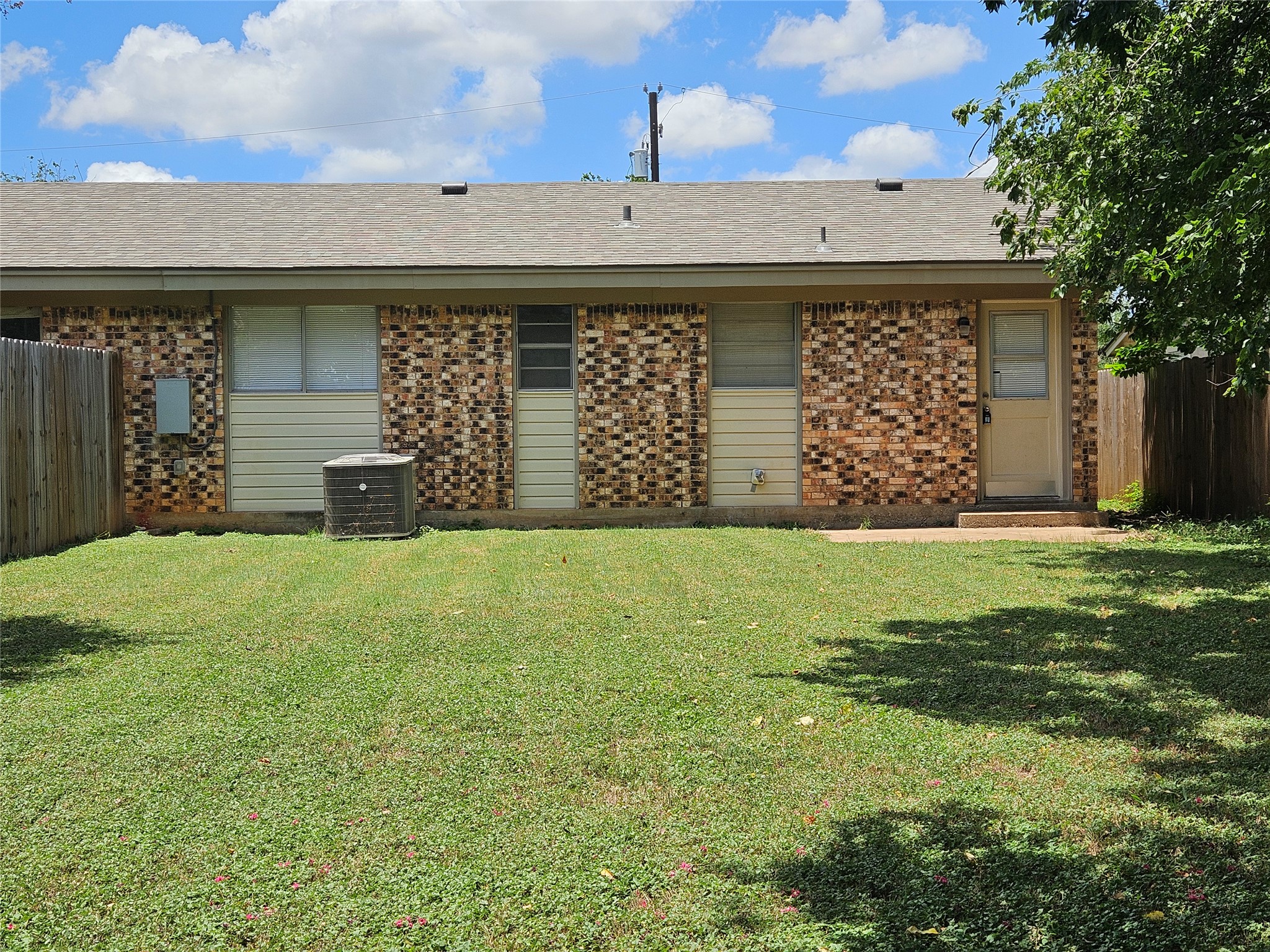 806 Ranch Road, Unit A Georgetown, TX 78628 - Photo 14 of 24 A well-kept green yard adjoins the home with a wooden privacy fence.