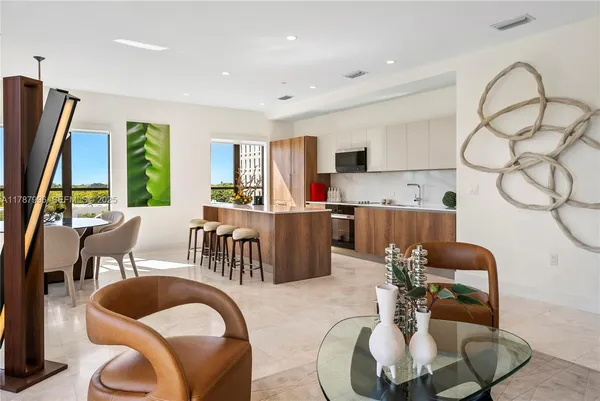 a living room with furniture kitchen view and a large window
