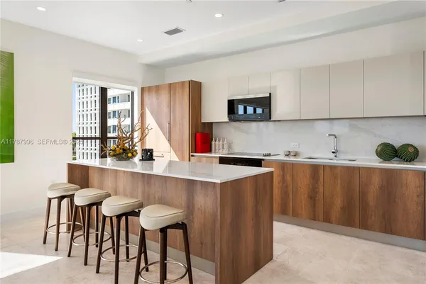 a kitchen with stainless steel appliances granite countertop a table chairs sink and cabinets