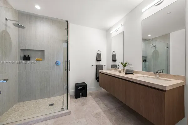 a bathroom with a double vanity sink toilet and shower