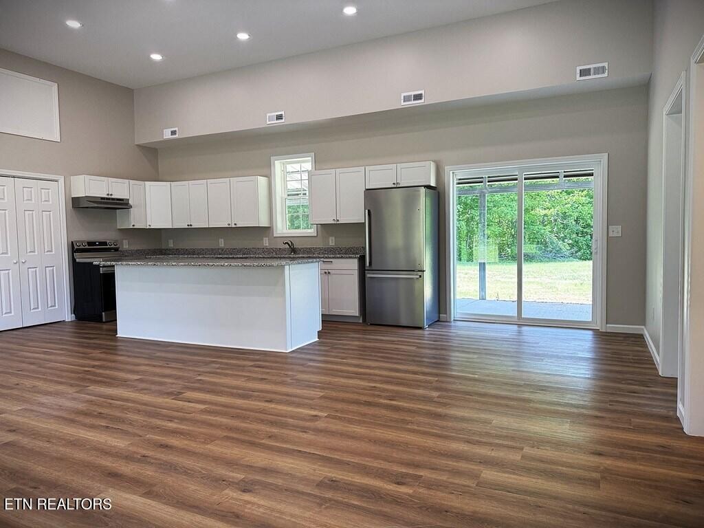 246 Ralph Spivey Lane Hilham, TN 38568 - Photo 37 of 53 a kitchen with stainless steel appliances granite countertop a refrigerator a stove top oven a sink and a wooden floor