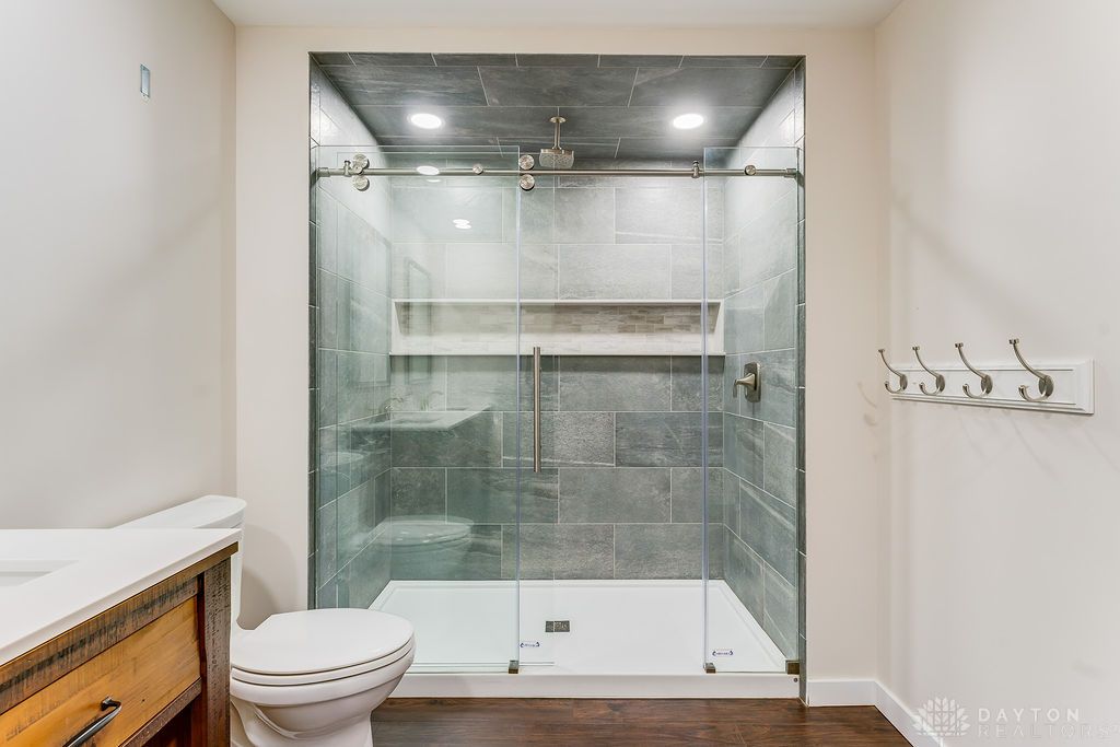 7400 Cook-Jones Road Waynesville, OH 45068 - Photo 31 of 72 This bathroom features a sleek glass-enclosed shower with contemporary tile work and dark wood flooring.